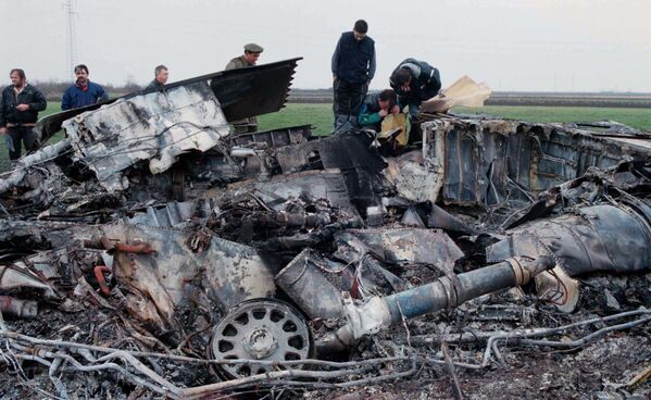 خبراء في الجيش اليوغوسلافي يفحصون حطام طائرة F-117 ستيلث التي تم إسقاطها في قرية بوديانوفتسي، على بعد 45 كيلومترًا (30 ميلاً) شمال غرب بلغراد، 28 مارس 1999. وأنقذ فريق الإنقاذ الطيار في حالة جيدة؛ وقال مسؤولون أمريكيون إنهم لا يعرفون سبب تحطم الطائرة. - سبوتنيك عربي