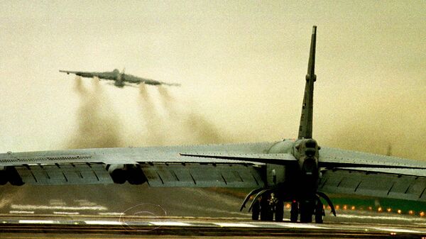 قاذفة B52 من طراز USAF على المدرج بينما تقلع أخرى من قاعدة سلاح الجو الملكي البريطاني في فيرفورد، على بعد 85 ميلاً غرب لندن يوم  29 مارس 1999 - سبوتنيك عربي