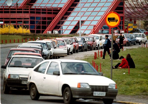السائقون يستريحون بجوار سياراتهم المتوقفة في طوابير لا نهاية لها أمام محطات الوقود في بلغراد يوم 24 مارس 1999 - سبوتنيك عربي