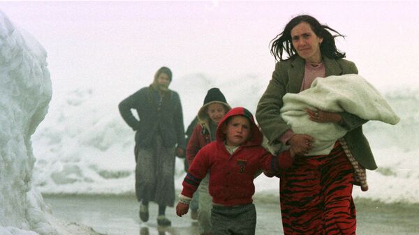 أم من كوسوفو تقود أطفالها الباكين خارج بيك، كوسوفو، يوغوسلافيا على طول طريق ثلجي يؤدي إلى إقليم الجبل الأسود اليوغوسلافي القريب يوم 31 مارس 1999 - سبوتنيك عربي