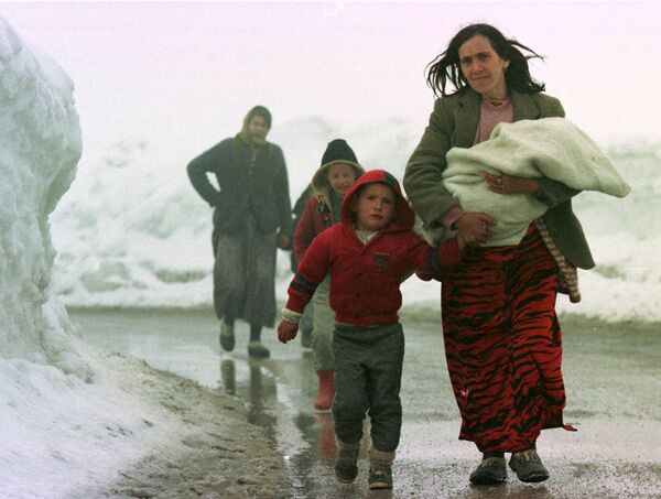 أم من كوسوفو تقود أطفالها الباكين خارج بيك، كوسوفو، يوغوسلافيا على طول طريق ثلجي يؤدي إلى إقليم الجبل الأسود اليوغوسلافي القريب يوم 31 مارس 1999 - سبوتنيك عربي