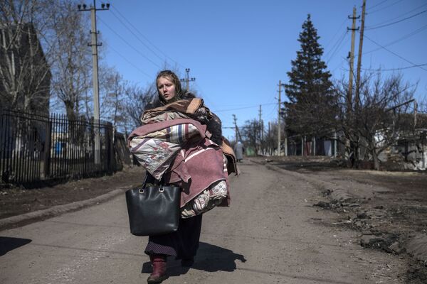 فتاة تحمل أغراضها في قرية فارفاروفكا، جمهورية لوغانسك الشعبية، إقليم دونباس، حدود روسيا 21 مارس 2022 - سبوتنيك عربي