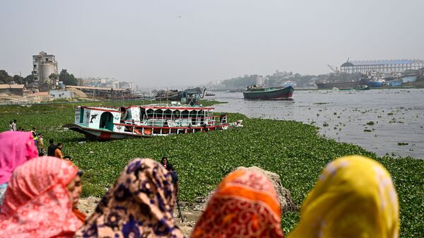 الناس يشاهدون العبارة التي تم إنقاذها في أعقاب حادث في نهر شيتالاكشيا في نارايانغاني، بنغلادش، 21 مارس 2022 - سبوتنيك عربي