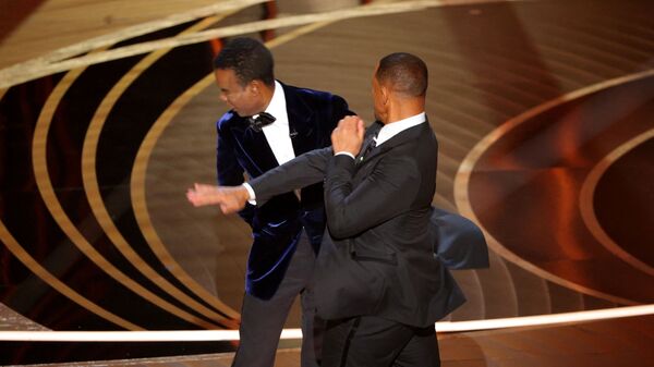 يضرب ويل سميث (يمين) كريس روك بينما تحدث روك على خشبة المسرح خلال حفل توزيع جوائز الأوسكار الـ94 في هوليوود، لوس أنجلوس، كاليفورنيا، الولايات المتحدة، 27 مارس/أذار 2022. - سبوتنيك عربي