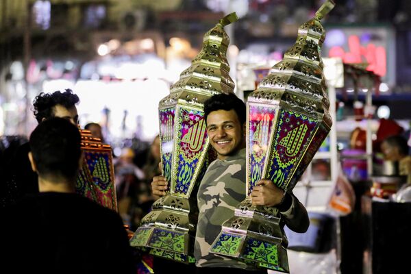 رجل يحمل فوانيس رمضانية تقليدية تسمى فانوس في كشك قبل شهر رمضان المبارك، في القاهرة، مصر، 31 مارس 2022. - سبوتنيك عربي