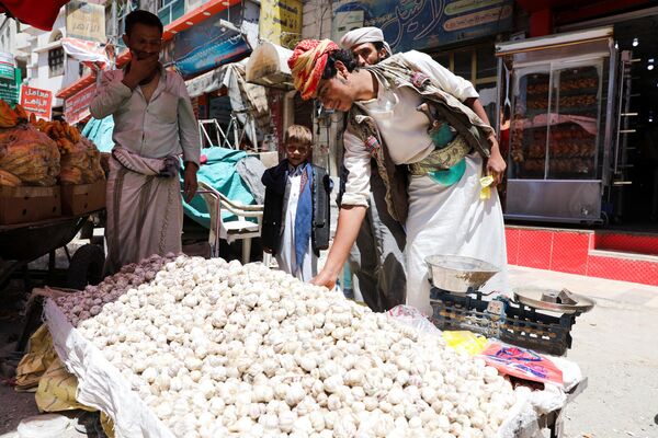 بائع يبيع الثوم ينتظر الزبائن في أحد الشوارع بينما يستعد اليمنيون لصيام شهر رمضان في صنعاء، اليمن، 1 أبريل 2022. - سبوتنيك عربي
