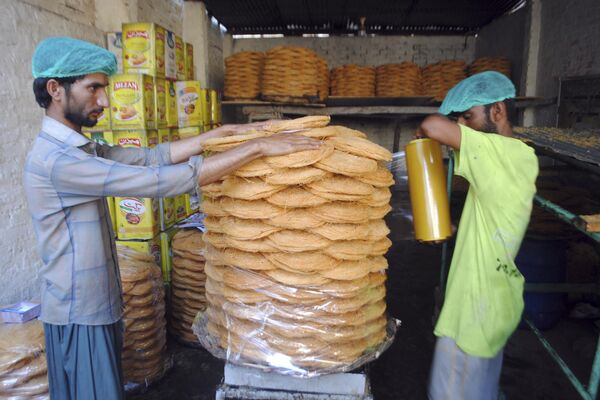 باكستانيون يصنعون الحلويات التقليدية في سوق لعرضها للبيع قبل شهر صيام رمضان القادم في حيدر أباد، باكستان، 2 أبريل 2022. - سبوتنيك عربي