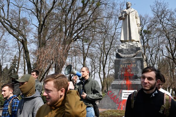 أعضاء المنظمة القومية C14 يخربون بطلاء أحمر نصب تذكاري للجنرال نيكولاي فاتوتين، بطل الاتحاد السوفيتي، الذي حارب ألمانيا النازية في الجبهة الأوكرانية الأولى، كييف 13 أبريل 2018 - سبوتنيك عربي