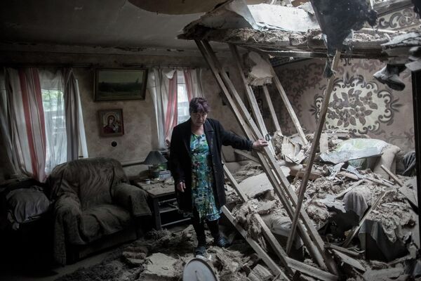 إحدى سكان قرية غولوبوفكا في منزلها بعد القصف. - سبوتنيك عربي