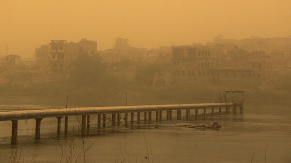 عاصفة رملية تجتاح مباني البلدة القديمة ، على ضفاف نهر دجلة في مدينة الموصل شمال العراق، في 7 أبريل 2022. - سبوتنيك عربي