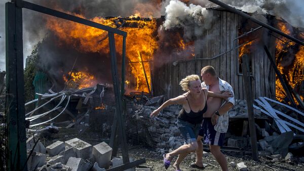 Местные жители спасаются от пожара, возникшего в результате авиационного удара вооруженных сил Украины по станице Луганская - سبوتنيك عربي