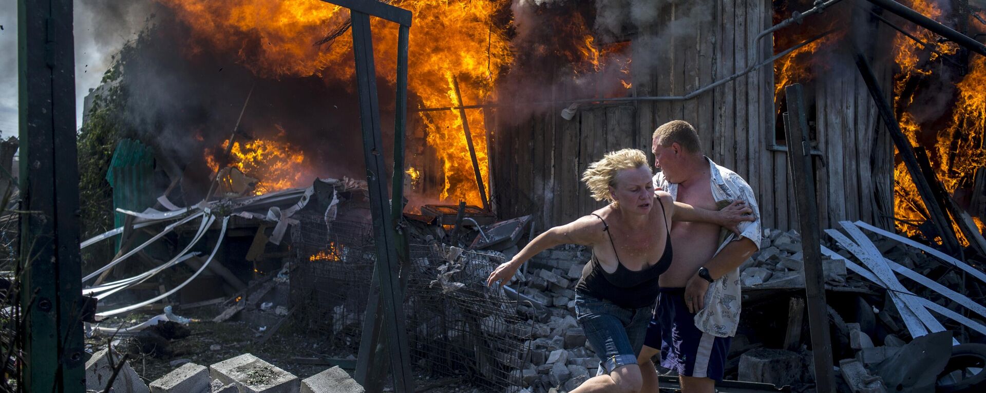 Местные жители спасаются от пожара, возникшего в результате авиационного удара вооруженных сил Украины по станице Луганская - سبوتنيك عربي, 1920, 11.04.2022