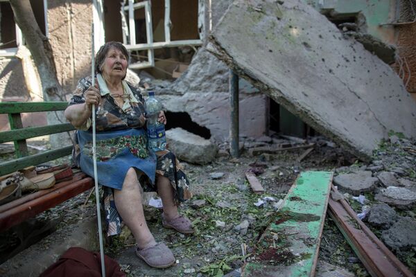  مايو/ أيار 2014. إحدى مواطنات مدينة سلافيانسك التي دمرت مدفعية الجيش الأوكراني دارها. - سبوتنيك عربي