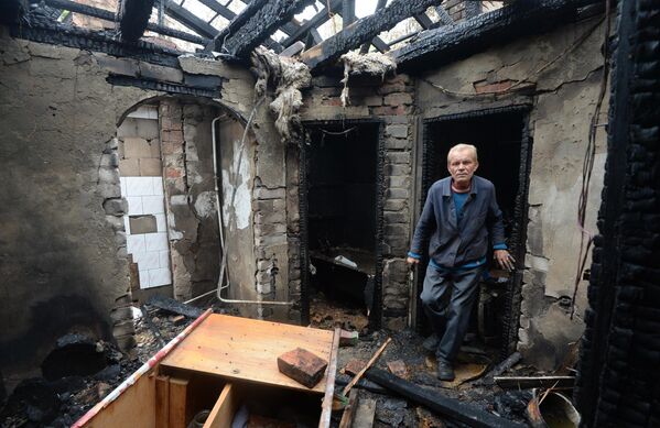يوليو/ تموز 2014. مواطن من سكان بلدة ملايا فيرغونكا في بيته الذي دمره قصف جوي من قبل الجيش الأوكراني. - سبوتنيك عربي