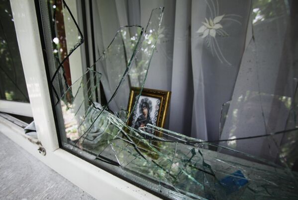  نافذة مدمرة لإحدى الدور في بلدة أكتوبر بمقاطعة دونيتسك التي تعرضت لقصف من قبل مدفعية الجيش الأوكراني في ليل 22 – 23 سبتمبر/أيلول 2019. - سبوتنيك عربي