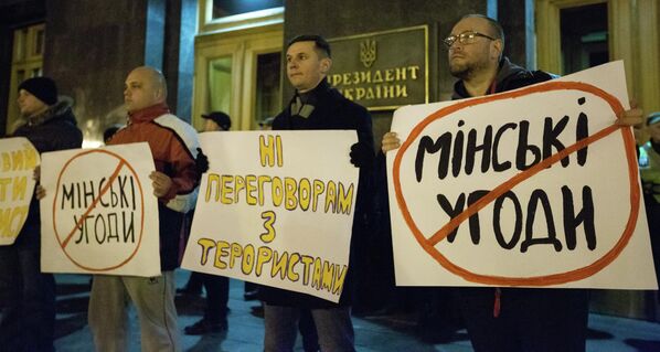 المشاركون في مسيرة معارضة بالقرب من مبنى الإدارة الرئاسية لأوكرانيا في كييف يطالبون بالتخلي عن المفاوضات مع دونباس، مارس 2020 - سبوتنيك عربي