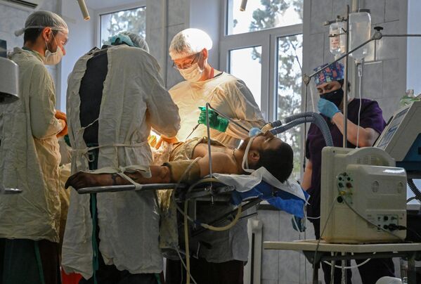 مسعفون يجرون عملية جراحية لجندي من القوات المسلحة الأوكرانية، الذي استسلم في ماريوبول، في مستشفى منطقة نوفوازوفسك المركزية. - سبوتنيك عربي