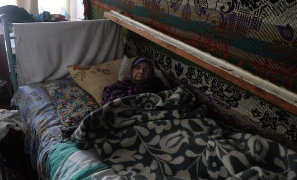 لم يكن بمقدور الجميع أن يختبئوا من هجمات الجيش الأوكراني في المخابئ تحت بيوتهم. وظل بعضهم موجودين في بيوتهم أثناء القصف لتقتلهم قذائف وقنابل الجيش الأوكراني. وتبدو في الصورة امرأة في التسعين من عمرها من سكان مدينة ديبالتسيفو في منزلها الذي جرّده الجيش الأوكراني من التدفئة والكهرباء. - سبوتنيك عربي
