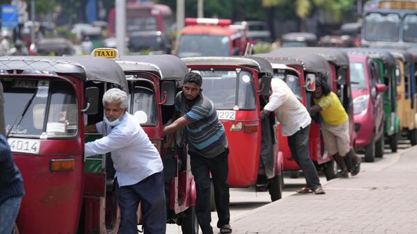 يصطف سائقو عربات الريكاشة السريلانكية لشراء البنزين بالقرب من محطة وقود في كولومبو، سريلانكا 13 أبريل 2022. - سبوتنيك عربي