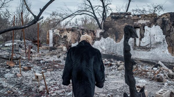 Женщина у разрушенного дома в поселке Саханка Донецкой области - سبوتنيك عربي