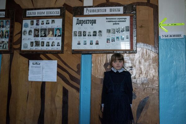 أصبح أطفال مدارس دونباس يميزون أصوات الغارات. وهم يعرفون جيدًا مكان المأوى من القذائف الأوكرانية.في الصورة: فتاة في مدرسة في قرية ساخانكا بمنطقة دونيتسك. بجانب صور المعلمين والخريجين - إشارة إلى الملجأ، مثل هذه الأسهم الملونة في كل مكان في المدرسة، من السهل العثور على ملجأ آمن أثناء القصف. - سبوتنيك عربي