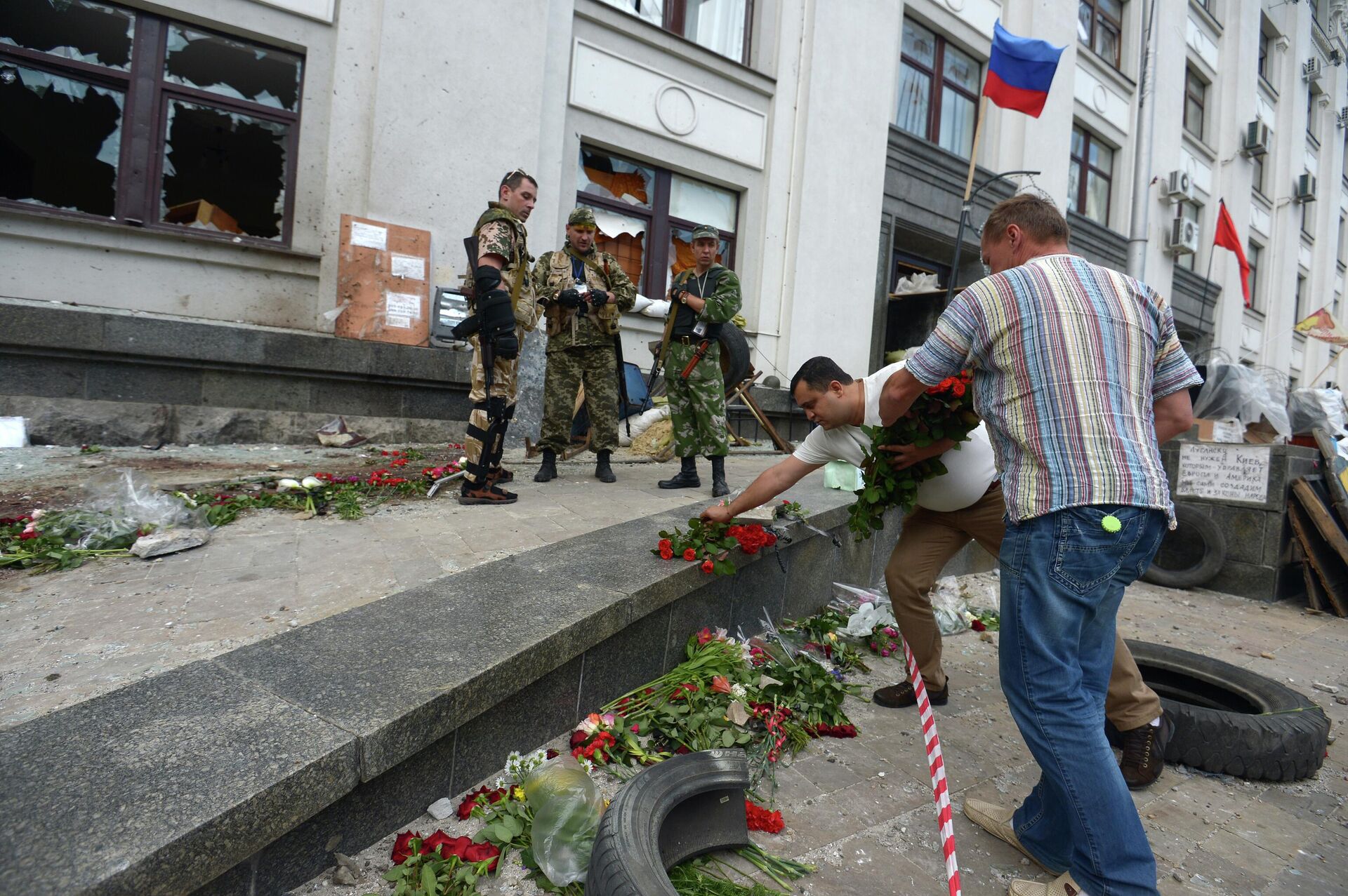 السكان يضعون الزهور في مبنى الإدارة الإقليمية في لوغانسك بعد الضربة الجوية الأوكرانية بتاريخ 2 يونيو 2014 (الصورة في 3 يونيو) - سبوتنيك عربي, 1920, 19.04.2022