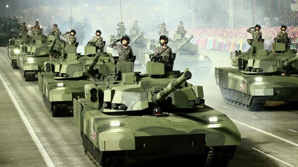 جنود كوروين يحييون الحضور من الدبابات خلال عرض عسكري للاحتفال بالذكرى الـ90 لتأسيس الجيش الثوري الشعبي الكوري الشمالي في كيم إيل. ساحة سونغ في بيونغ يانغ. 25 أبريل 2022 - سبوتنيك عربي