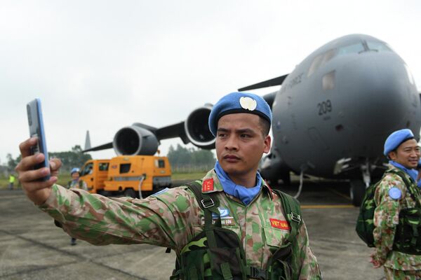 عضو في قوة حفظ السلام التابعة للأمم المتحدة الفيتنامية يلتقط صورة سيلفي على متن الطائرة في حفل مغادرة القوة للمشاركة في مهمة حفظ السلام في جنوب السودان في هانوي في 27 أبريل 2022. - سبوتنيك عربي