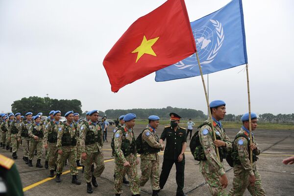 القوات الفيتنامية المشاركة في بعثة الأمم المتحدة لحفظ السلام في جنوب السودان تسير في مسيرة رافعة الأعلام قبل مغادرتها هانوي في 27 أبريل 2022. - سبوتنيك عربي