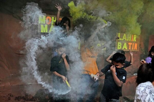 يشعل الفتيان قنابل الدخان أثناء احتفالهم عشية عيد الفطر في جاكرتا، إندونيسيا 1 مايو 2022. - سبوتنيك عربي