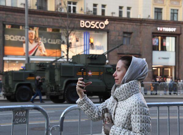 فتاة تلتقط صورا لمركبات عسكرية سائرة في وسط مدينة موسكو - سبوتنيك عربي