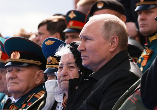 الرئيس فلاديمير بوتين يجلس بين المحاربين القدامى خلال العرض العسكري بمناسبة الذكرى الـ77 لعيد النصر في الساحة الحمراء، موسكو، روسيا 9 مايو 2022 - سبوتنيك عربي