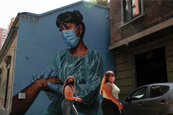 نساء تسير على خلفية لوحة جدارية لممرضة في سانتياغو، تشيلي - سبوتنيك عربي