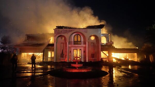 Пожарные тушат строение, горящее во время лесного пожара, в Лагуна-Нигель, Калифорния - سبوتنيك عربي