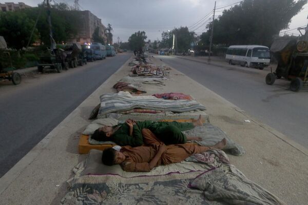 ينام العمال على منتصف الطريق خلال صباح صيفي حار مبكرًا في كراتشي، باكستان، 11 مايو 2022. استمرت مدينة كراتشي الساحلية الباكستانية وبعض الأجزاء الأخرى من البلاد في مواجهة موجة حر شديدة في هذه الأيام. - سبوتنيك عربي