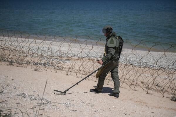 عنصر من القوات المسلحة الروسية يتفقد الشاطئ في منطقة أراباتسكايا ستريلكا - سبوتنيك عربي