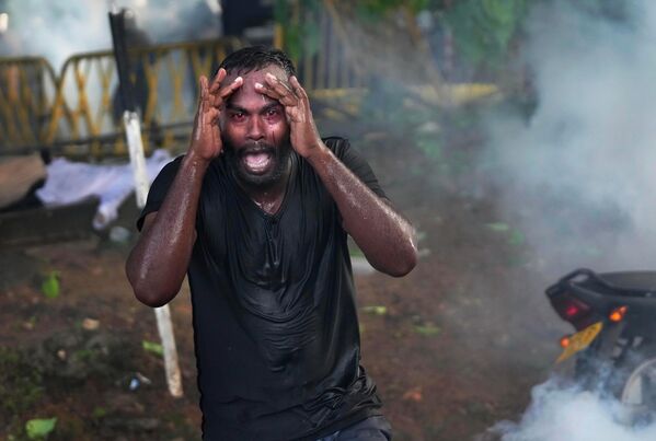 متظاهر مصاب بالغاز المسيل للدموع خلال مواجهات مع الشرطة في العاصمة السريلانكية، 19 مايو عام 2022 - سبوتنيك عربي