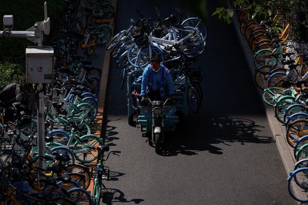 طاقم يقوم بترتيب دراجات عامة غير مستخدمة بسبب انتشار فيروس كورونا في العاصمة الصينية بكين، 16 مايو عام 2022 - سبوتنيك عربي