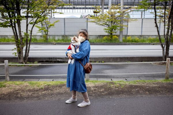 امرأة مع كلبها في منتجع كارويزاوا، اليابان 21 مايو 2022. - سبوتنيك عربي