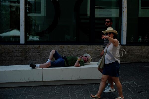 سائح يستريح بينما يمشي الناس خلال يوم ربيعي مشمس، في بينيدورم، جنوب شرق إسبانيا،21 مايو 2022. - سبوتنيك عربي