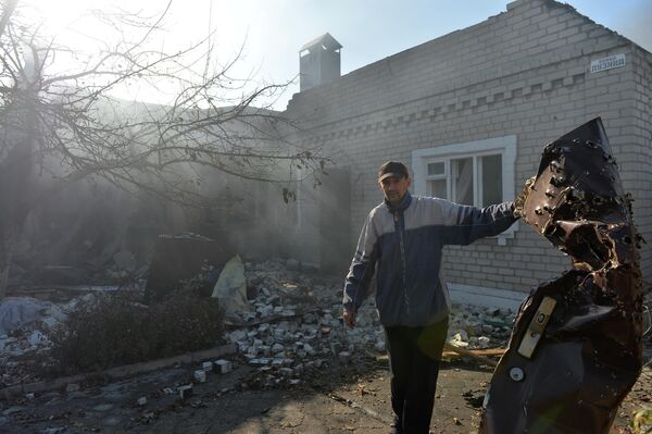 الباب المعدني الذي يحمله هذا الساكن في دونيتسك مليء بشظايا قذيفة أوكرانية. - سبوتنيك عربي