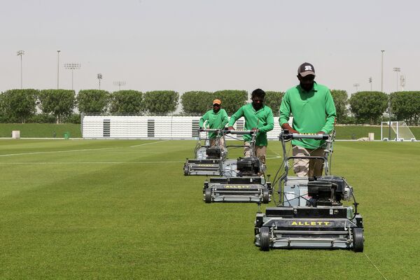  أعضاء الطاقم يقطعون العشب في منشأة تدريب العقلة (al-Egla) في العاصمة الدوحة، قطر 30 مايو 2022. - سبوتنيك عربي