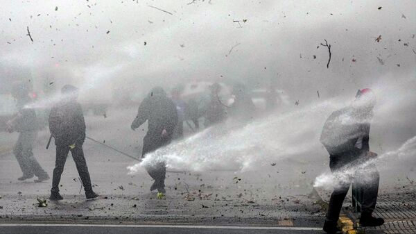 تم رش المتظاهرين بخراطيم المياه الخاصة بالشرطة خلال مظاهرة طلابية في سانتياغو، تشيلي، 27 مايو  2021.
 - سبوتنيك عربي