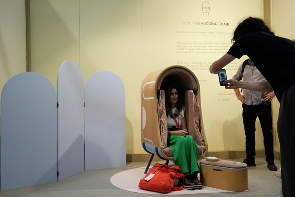 زائرة تلتقط صورة في كرسي من تصميم أوتو للأثاث (Oto)، في إطار معرض ديزاين فير (Design Fair) في ميلانو، إيطاليا، 7 يونيو 2022. - سبوتنيك عربي