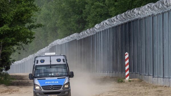 سيارة شرطة تقوم بدوريات على طول الجدار الحدودي عند الحدود البولندية البيلاروسية بالقرب من قرية تولتش، في مقاطعة سوكولكا، محافظة بودلاسكي، في شمال شرق بولندا في 8 يونيو 2022 - سبوتنيك عربي