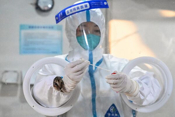 قطة داخل غلاف بدلة الخطر لعامل صحي في شنغهاي في 6 يونيو عام 2022. - سبوتنيك عربي