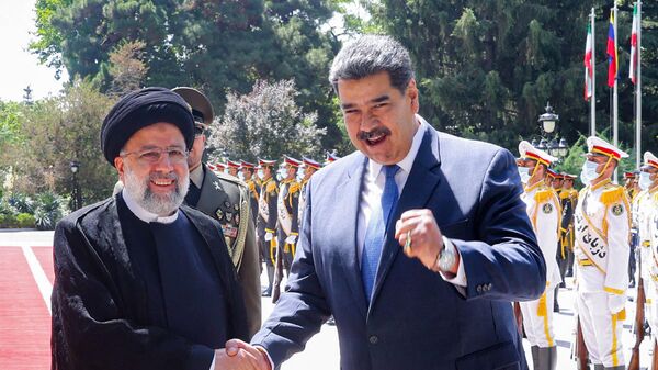 الرئيس الفنزويلي، نيكولاس مادورو، يصافح نظيره الإيراني، إبراهيم رئيسي، في العاصمة الإيرانية طهران، 11 يونيو/ حزيران 2022 - سبوتنيك عربي