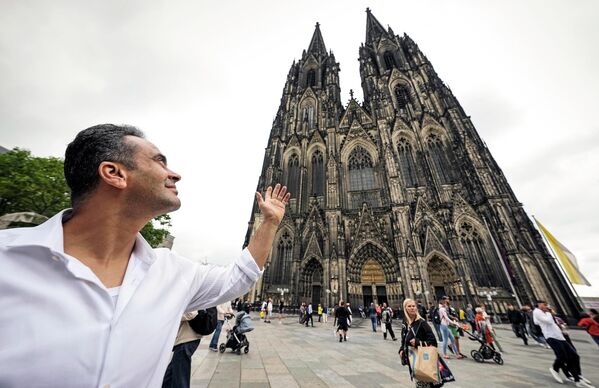 فاضل الخضر من سوريا يقف بالقرب من كاتدرائية كولونيا بألمانيا، الاثنين 20 يونيو 2022. - سبوتنيك عربي