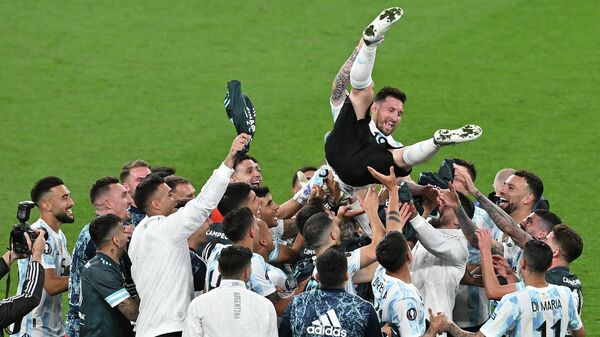 لاعبو فريق الأرجنتين يرفعون المهاجم الأرجنتيني ليونيل ميسي إلى الهواء أثناء احتفالهم بالفوز في مباراة كرة القدم الدولية الودية بين إيطاليا والأرجنتين على ملعب ويمبلي بلندن في 1 يونيو 2022 - سبوتنيك عربي