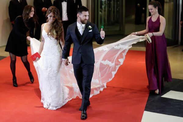 ليونيل ميسي المتزوج حديثًا يومض بإبهامه وهو يخرج هو وعروسه أنتونيلا روكوزو على السجادة الحمراء - سبوتنيك عربي